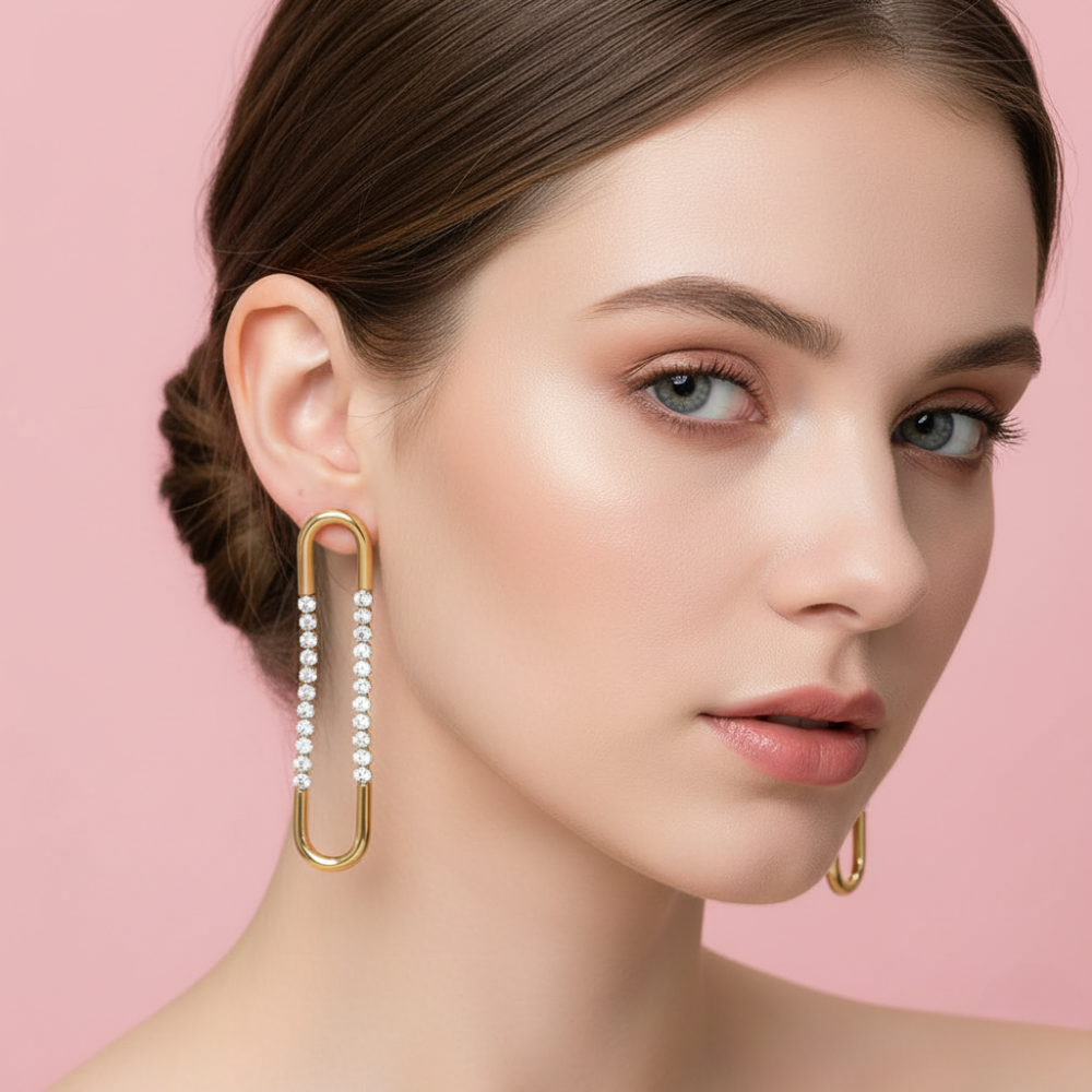 Gold hoop earrings with embedded diamonds on a pink background