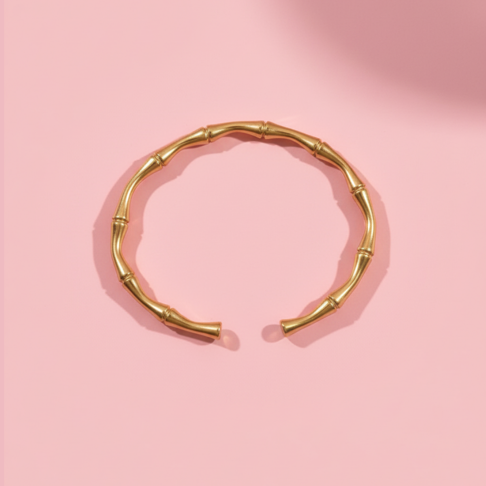 Gold bracelet on a pink background