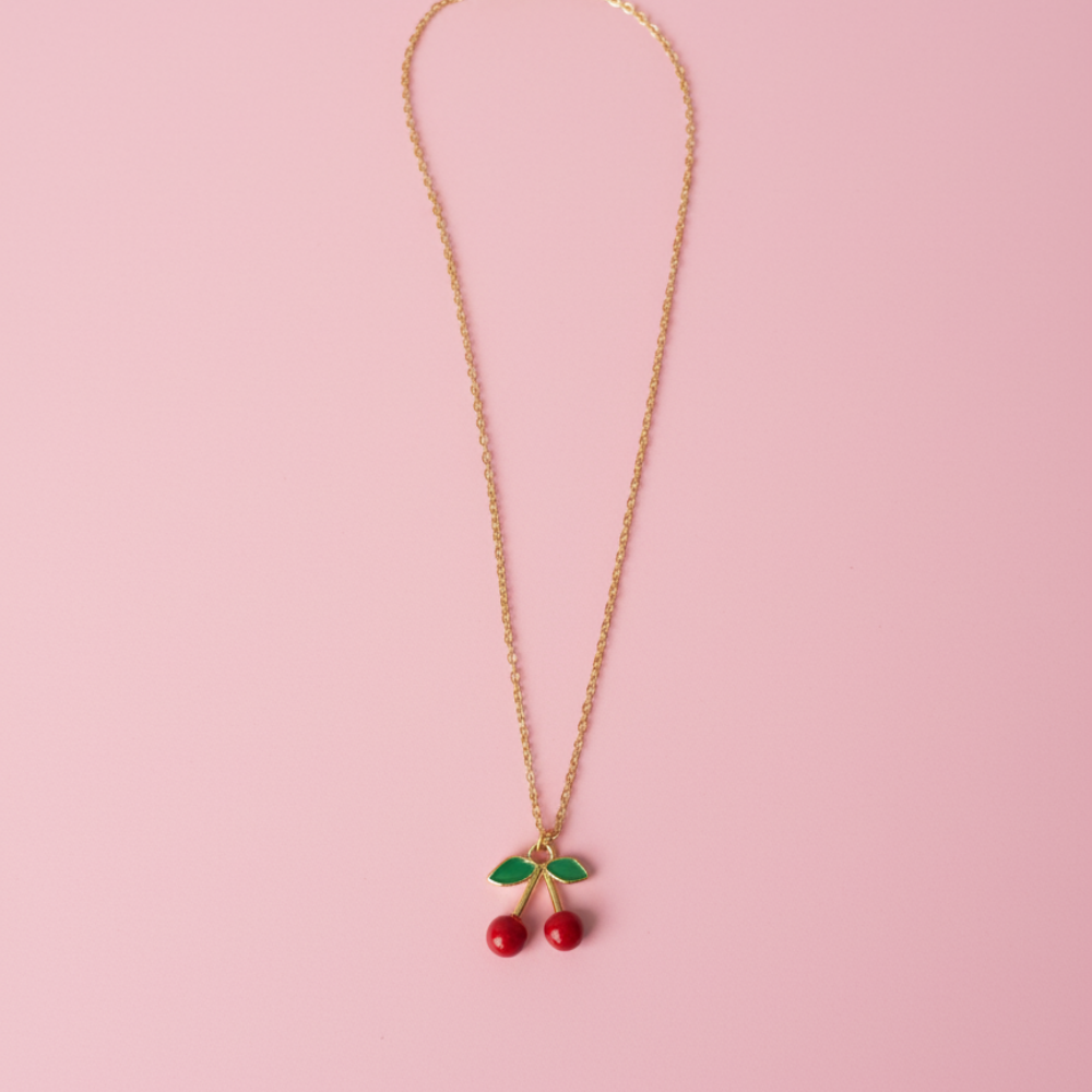Necklace with cherry pendants on a pink background