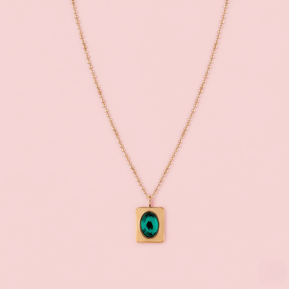 Necklace with a green pendant on a pink background